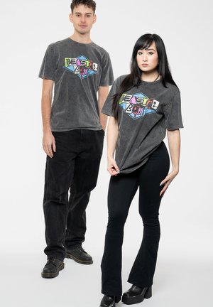 Gray vintage-style t-shirts feature a colorful graphic "Beastie Boys." Models wear black pants and boots on a plain white background.