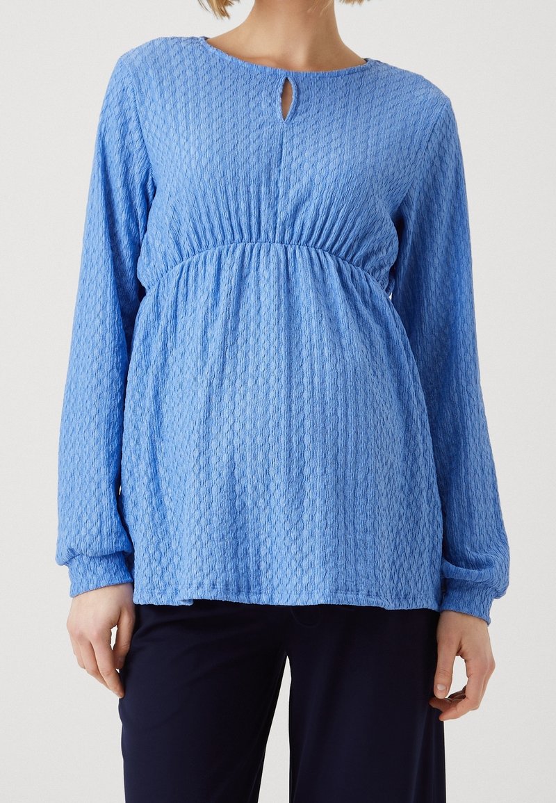 Blå strukturerad långärmad topp med rund halsringning och nyckelhålsdetalj framtill, med en samlad midja och avslappnad passform.