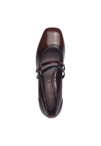 Chaussure en cuir verni marron de style Mary Jane avec deux fines lanières et un bout carré. Texture lisse avec une finition brillante. Logo imprimé dans la semelle intérieure.