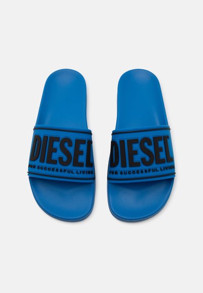 Сини сандали за плуване с широка черна лента, на която е изписана марката "DIESEL" с големи букви и фразата "ЗА УСПЕШЕН ЖИВОТ" с по-малък текст.