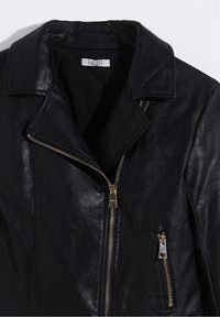 Černá kožená bunda s límcem, stříbrným kováním a asymetrickým zipem. Disponuje boční kapsou se shodným zipem. Hladká textura.