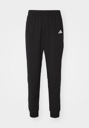 Svarta träningbyxor med resårmidja, muddar vid anklarna och vit Adidas-logotyp på vänstra låret. Tillverkade av lätt och slät tyg.