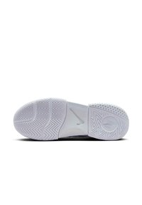 Bijela atletska cipela s potplatom od teksturirane gume, koja ima riblju kost uzorak, kružne grip detalje i Nike swoosh logo.