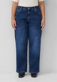 Ciemnoniebieskie dżinsy o szerokich nogawkach z pięcioma kieszeniami, z zapięciem na guzik i zamek błyskawiczny oraz delikatnie wyblakłymi miejscami. Posiadają przeszycia na kieszeniach.