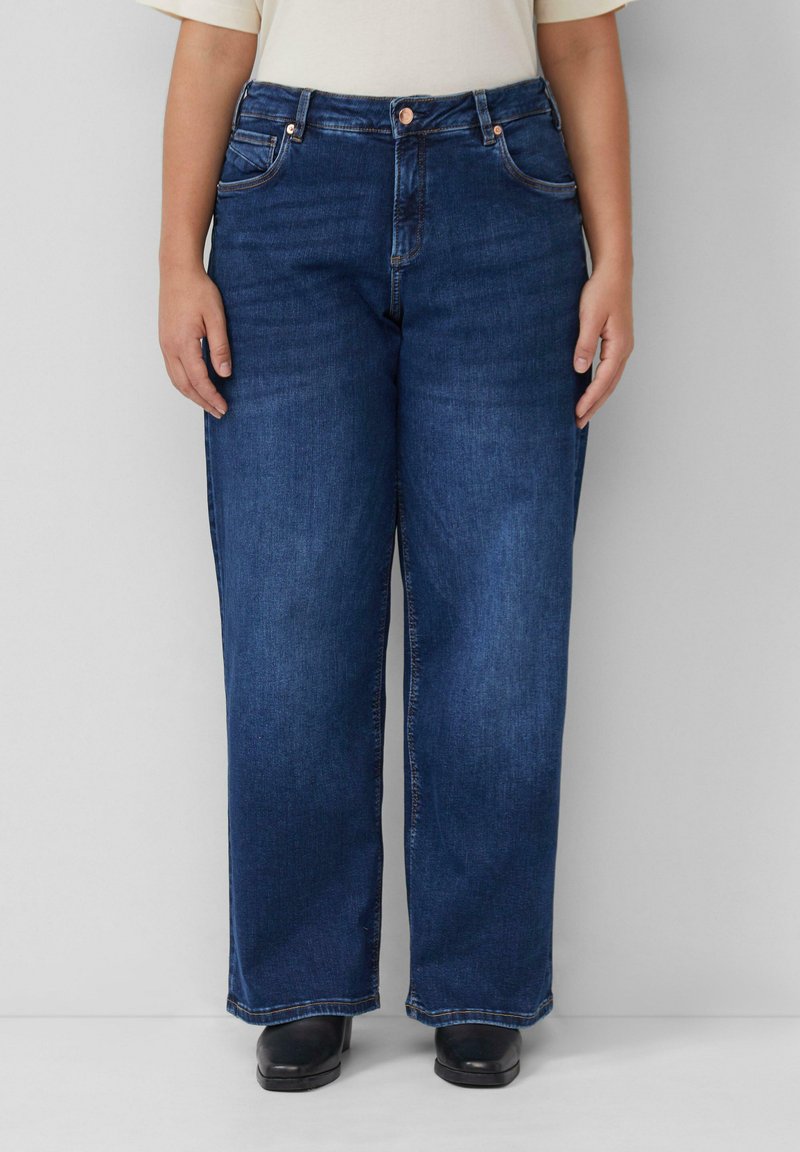 Ciemnoniebieskie dżinsy o szerokich nogawkach z pięcioma kieszeniami, z zapięciem na guzik i zamek błyskawiczny oraz delikatnie wyblakłymi miejscami. Posiadają przeszycia na kieszeniach.