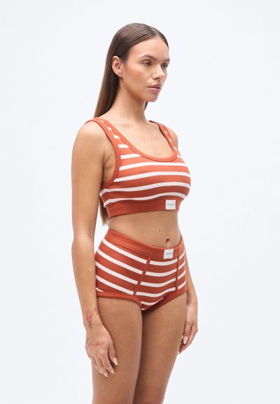 Ριγέ μπουστάκι και σλιπ ψηλόμεσο σε αποχρώσεις σκουριάς και κρέμας, με ραβδωτή υφή και ετικέτα λογότυπου στη μέση.