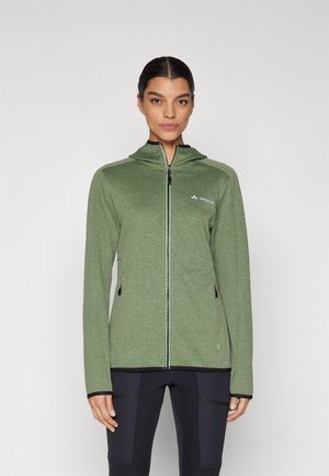 Groene ritssluitingjack met een capuchon, gemaakt van textuurstof. Heeft zijzakken, contrasterende zwarte accenten en een klein logo op de borst.