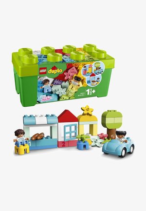 Set LEGO Duplo 10913 con una caja verde, bloques multicolores y dos figuras. Incluye casas, un árbol, flores y un coche azul.