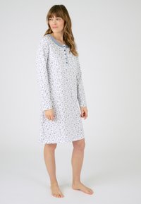 Vestido de noche de manga larga en algodón gris claro con un patrón de hojas, escote azul en contraste y tapeta de botones. Ajuste a la altura de la rodilla.