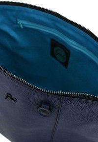 Sac en cuir bleu foncé avec un extérieur texturé, fermeture éclair, et une doublure intérieure turquoise vif. Comprend un bouton-pression et un détail de logo.