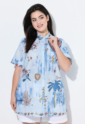 Chemise à manches courtes bleu clair avec un design à boutons, ornée d'imprimés graphiques colorés d'étoiles, de palmiers et d'yeux sur un tissu texturé.