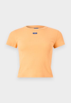 Kurzärmeliges, kurz geschnittenes orangefarbenes T-Shirt mit Rippenstruktur und einem kleinen blauen "HUGO"-Logoaufnäher in der Mitte der Brust.