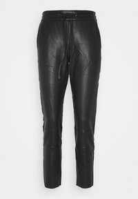 Pantalons en cuir noir avec une taille à cordon, effilés aux chevilles, présentant une texture lisse et des détails cousus pour un design amélioré.