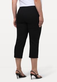 Zwarte cropped broeken met een rechte pijpz design, gemaakt van een zachte stof, met een gladde textuur en zonder zichtbare patronen.