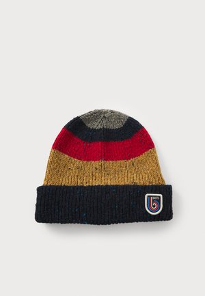 Bonnet en tricot avec des rayures multicolores : gris, rouge, moutarde et bleu foncé. Dispose d'un revers côtelé et d'un écusson logo blanc.