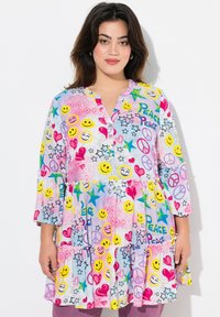 Multikleurige jurk met lachende gezichten, harten en sterren in roze, geel en blauw. Heeft een knoopsluiting bij de halslijn en een gelaagd ontwerp. Gemaakt van katoen.