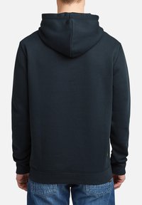 Sudadera azul marino hecha de una tela suave, con una capucha amplia, puños acanalados y un dobladillo recto. La parte trasera presenta un detalle minimalista.