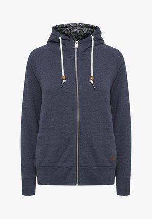 Haut à capuche zippé en marine avec un motif hexagonal à l'intérieur de la capuche, présentant des cordons blancs avec des accents en bois et des bords côtelés au niveau des poignets et de l'ourlet.