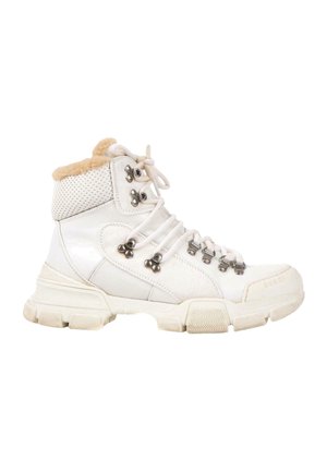 High-top white leather boot with thick sole, metal lace hooks, mesh panel, and beige fur lining around the ankle.