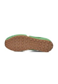 Soletta in felt verde con suola in gomma marrone, caratterizzata da puntini di trazione arrotondati e un logo brandizzato in un inserto rettangolare.