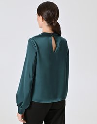 Blusa di raso teal con maniche lunghe, vestibilità rilassata e un piccolo dettaglio a chiave sul retro. Texture liscia e finitura morbida e lucida.