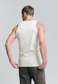 Witte katoenen tanktop met een ronde halslijn en ruime armsgaten, voorzien van een rechte zoom en een gladde textuur. Draag met donkere broek.