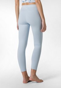 Leggings azzurri chiari realizzati in tessuto elasticizzato, con una vita alta e un design elegante e aderente che si restringe alla caviglia.