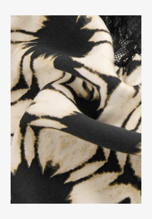 Schwarzer und beige blumenmusterter Stoff mit weicher Textur, der unregelmäßige Formen und ein leichtes Gefühl aufweist. Beinhaltet zarte schwarze Spitzenakzente.