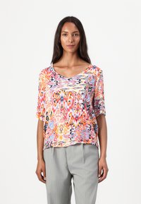 Top colorato a maniche corte con scollatura a V, caratterizzato da un vivace motivo astratto nelle tonalità di arancione, rosa e blu. Tessuto leggero.