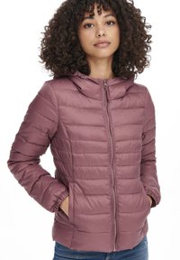 Veste doudoune rose avec capuche, texture matelassée, fermeture éclair à l'avant et poches latérales ; présente des poignets élastiques pour une meilleure isolation.