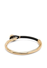 Pulsera de metal en tono dorado con un diseño suave y curvado, que cuenta con un cordón de cuero negro para el cierre y un pequeño acento redondo.
