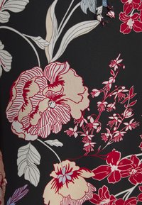 Tecido floral com grandes peónias vermelhas e creme e flores menores sobre um fundo preto. Textura suave e design fluido.