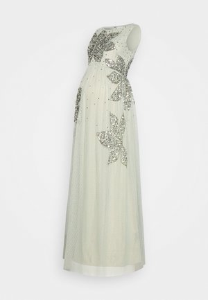 Robe longue blanche sans manches avec sequins floraux argentés et petit motif à pois, présentée sur un mannequin sans tête ni bras.