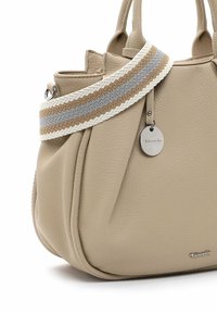 Sac à main en cuir beige avec une finition texturée, doté de doubles poignées et d'une bandoulière tissée à motifs en beige, gris et blanc. Étiquette logo en argent attachée.