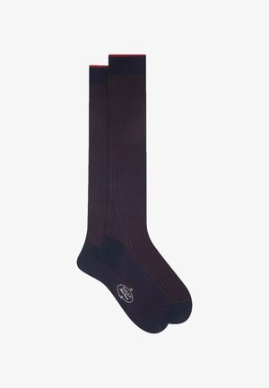 Calze alte fino al ginocchio di un blu navy scuro con strisce verticali bordeaux. Presentano una punta e un tallone in tinta unita con una fascia superiore a coste. Realizzate in materiale morbido e elastico.