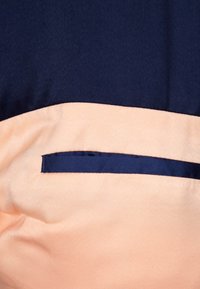 Marineblaue und pfirsichfarbene Stofftafel mit glatter Textur, die einen schmalen marineblauen Streifen über dem oberen pfirsichfarbenen Abschnitt aufweist.