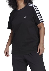 Svart bomulls-t-shirt med rund halsringning, korta ärmar och tre vita ränder längs axlarna. Liten vit logotyp på bröstet.