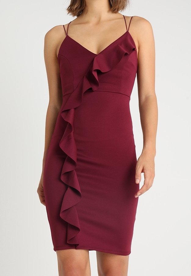 Robe bustier bordeaux avec bretelles spaghetti et un détail de volants sur le côté. Fabriquée en matière stretch, elle présente une silhouette ajustée.