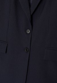 Blazer bleu marine à fines rayures, doté de deux boutons noirs, de revers crantés et de deux poches avant avec une finition en tissu texturé.