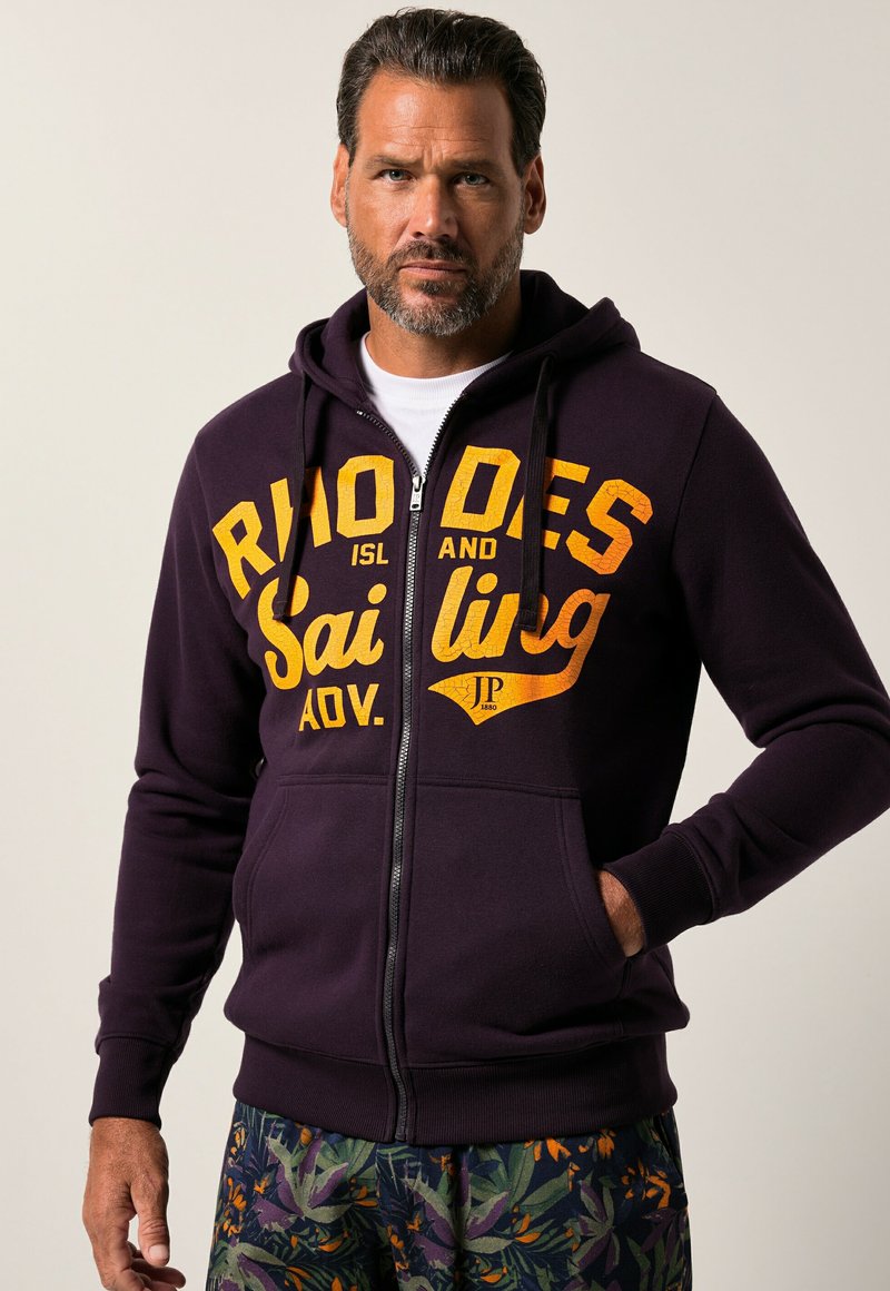 Lilla zip-up hoodie med orange tekst, der står "RHODES ISL AND Sailing AOV." Udstyret med snoretræk i hætten og forlommer.