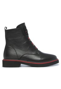 Bottine en cuir noir avec un bout rond, des coutures rouges, des accents texturés et une semelle en caoutchouc. Dispose d'une languette pour un enfilage facile.