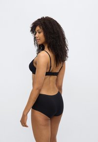 Σετ μαύρου εσωρούχου με σουτιέν με ρυθμιζόμενες τιράντες και κούμπωμα με γάντζο, συνδυασμένο με μαύρο σλιπ ψηλόμεσο. Απλός, άνετος σχεδιασμός χωρίς ραφές.