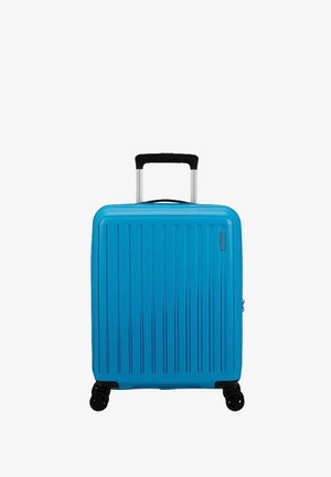 Compact blauwe koffer met verticale groeven, een zwarte uittrekbare handgreep en vier zwarte wielen voor gemakkelijke mobiliteit. Ritssluiting aan de zijkant.