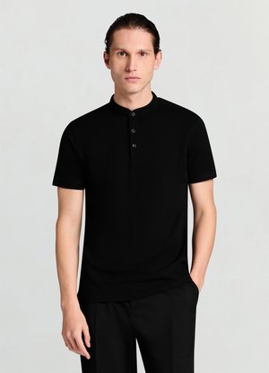 Polo nera a maniche corte con una texture sottile, dotata di collo alla coreana e patta con tre bottoni. Indossata con pantaloni neri su misura.
