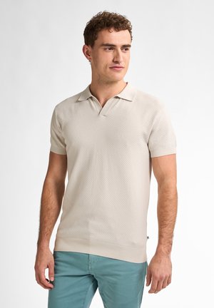 Beige pletená polo košile s žebrovanou texturou, krátkými rukávy a límcem ve tvaru V, doplněná o světle tyrkysové kalhoty.