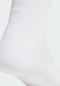 White cotton blend sock with ribbed texture and smooth finish. Features a mid-calf height with a seamless toe design. No visible branding.