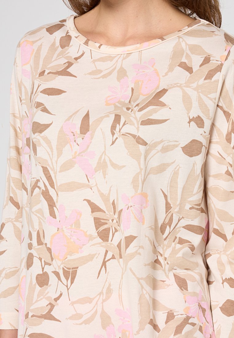 Lichtbeige top met een bloemenpatroon in roze en bruintinten, met een ronde halslijn en driekwartmouwen, gemaakt van zachte stof.