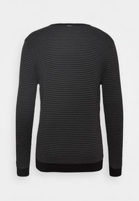 Pull noir en maille avec un motif à rayures texturées, col rond et manches longues. Poignets et ourlet côtelés pour une coupe ajustée.