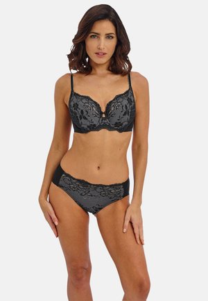 Bralette de encaje negro con patrón floral, escote en V y tirantes ajustables. Panties de hipster de encaje negro a juego con paneles laterales sólidos.