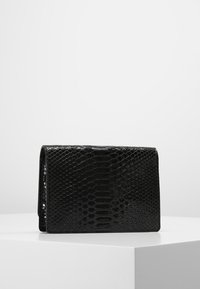 Černá kabelka z umělé kůže s lesklým, embosovaným hadím vzorem, vybavená překlopným víkem a minimalistickým designem.
